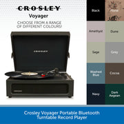 Crosley Voyager portable Bluetooth turntable record player shown open with a vinyl record on the turntable, alongside a color selection chart listing Black, Floral, Amethyst, Dune, Sage, Grey, Washed Blue, Cocoa, Navy, and Dark Aegean.
