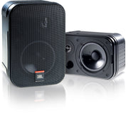 A pair of JBL Control 1 Pro wall speakers, one in black and one in white, each with a front-firing woofer and a tweeter.