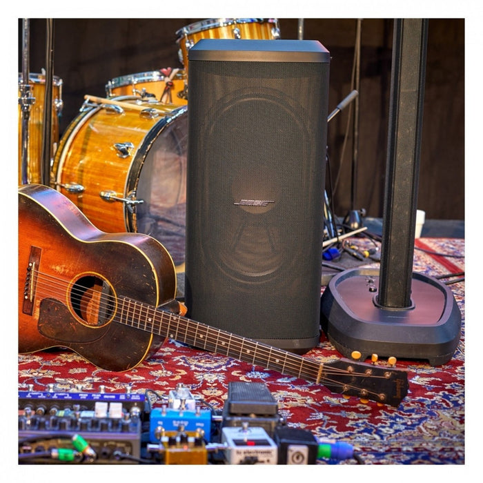 Acoustic guitar, speaker, and musical equipment on a patterned surface